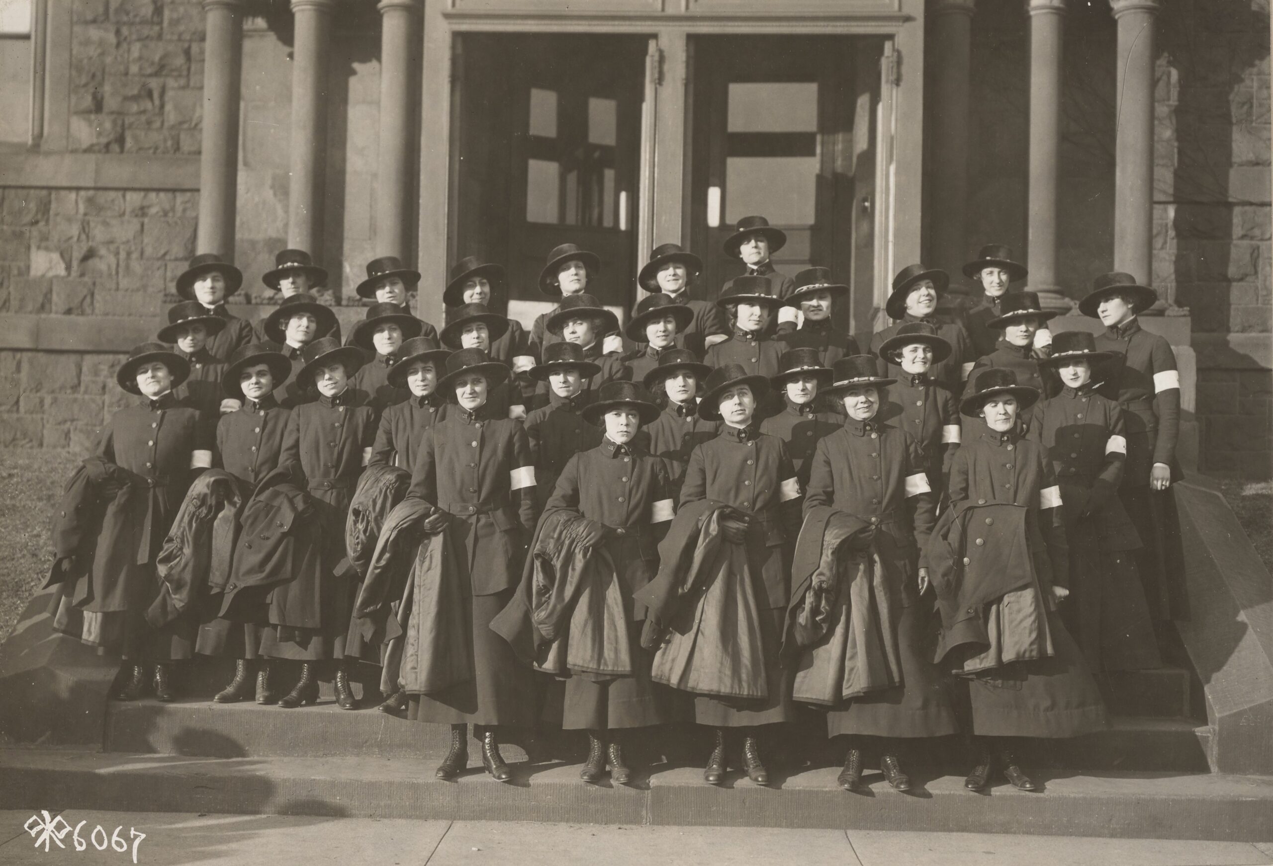 First Group of Signal Corps women, in uniform on the steps of a building